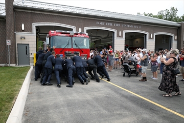 Firefighters pushing their vehicle inside the station as part of the grand opening celebrations.